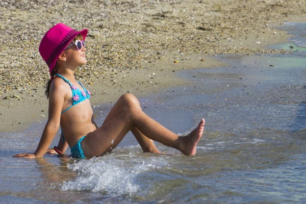 Dziewczynka z tabletu na plaży podczas letnich wakacji — Zdjęcie stockowe