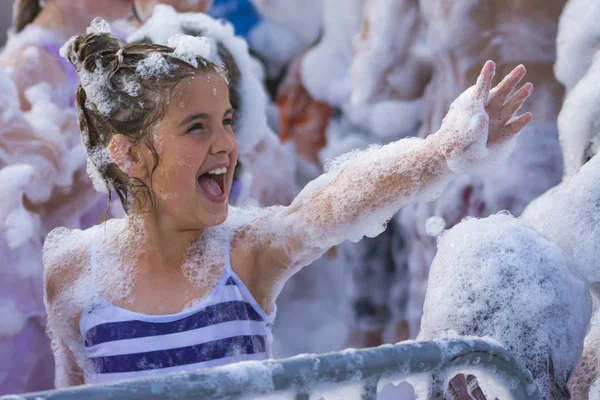 Köpük partisi sahilde. Sevimli küçük kız ve dans eğlenceli sahip.