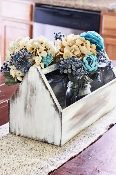 Boîte à outils antique en bois avec fleurs sur la table de ferme — Photo