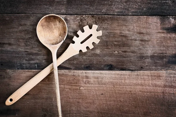 Träsked och Spaghetti gaffel över trä bakgrund — Stockfoto