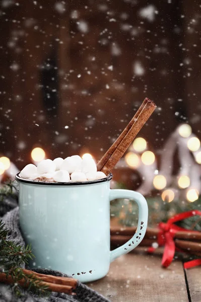 Kakao mit Marshmallows und Zimtrinde bei fallendem Schnee — Stockfoto