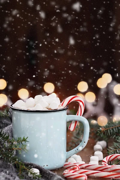 Cacau com marshmallows e bastões de doces com neve em queda — Fotografia de Stock