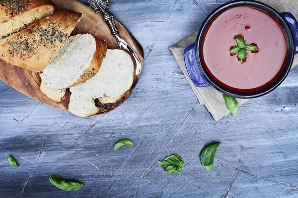 Sopa de tomate quente com folhas de manjericão e pão cru — Fotografia de Stock