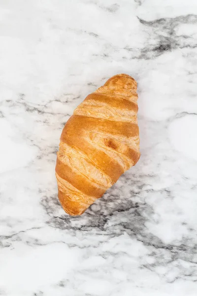 Croissant na marmurowym tle — Zdjęcie stockowe