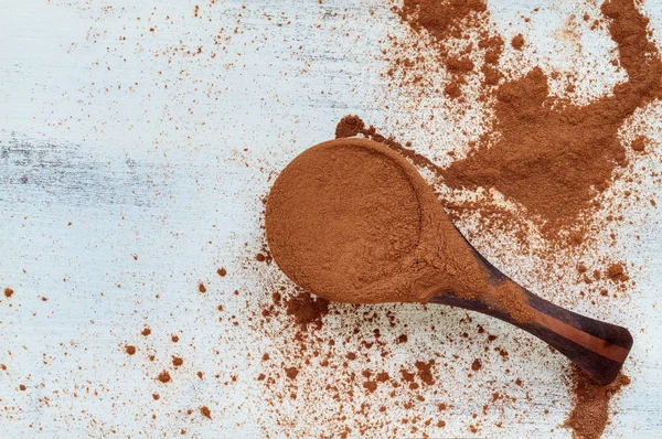 Cuchara de medición de madera derramando polvo de canela — Foto de Stock