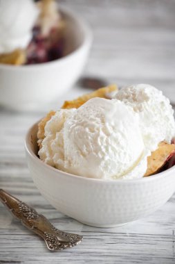 İki kepçe vanilyalı dondurmayla servis edilen taze ev yapımı vişneli tart. Bulanık arkaplan ile seçmeli odak.