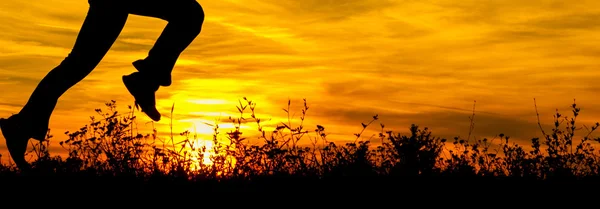 Силуэты бегущих на природе ног бегущих на летнем рассвете . — стоковое фото