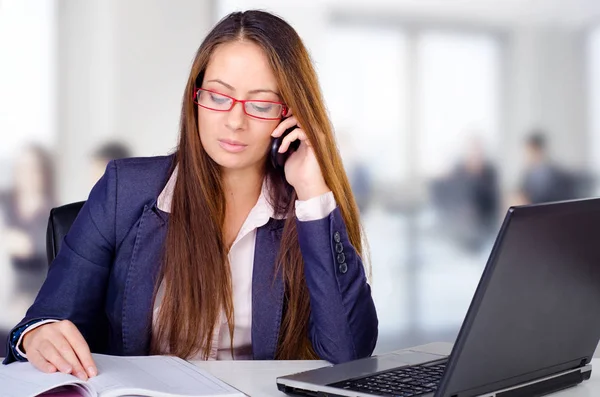 Beautiful young business woman making a phone call from her office — Stock Photo, Image