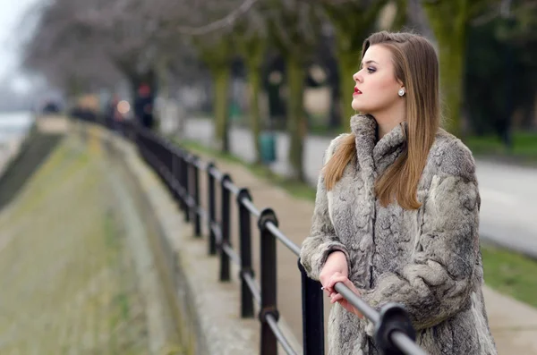 Elégante fille en manteau de fourrure marchant seule dans la ruelle de la ville le jour d'automne froid — Photo