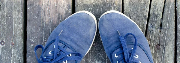 Ноги в кроссовках стоят на деревянном полу — стоковое фото