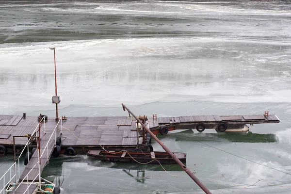 Muelle del río y barco pesquero en el río congelado durante el frío invierno —  Fotos de Stock