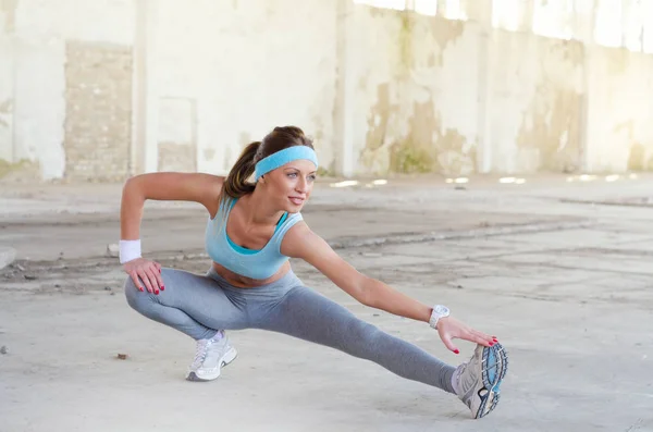 Souriant fitness girl étirement et exercice en plein air — Photo