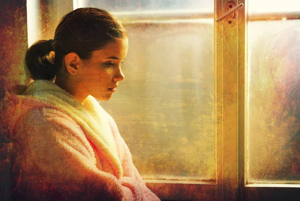 Mooi ziek verdrietig meisje in nachthemd op zoek staande naast ziekenhuis venster — Stockfoto