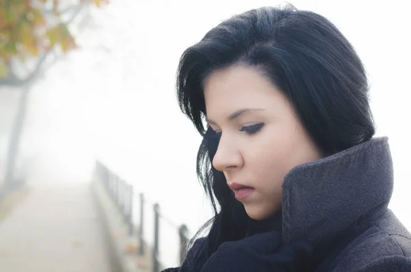 Portrait of sad girl standing outdoor on misty autumn day — Stock Photo, Image