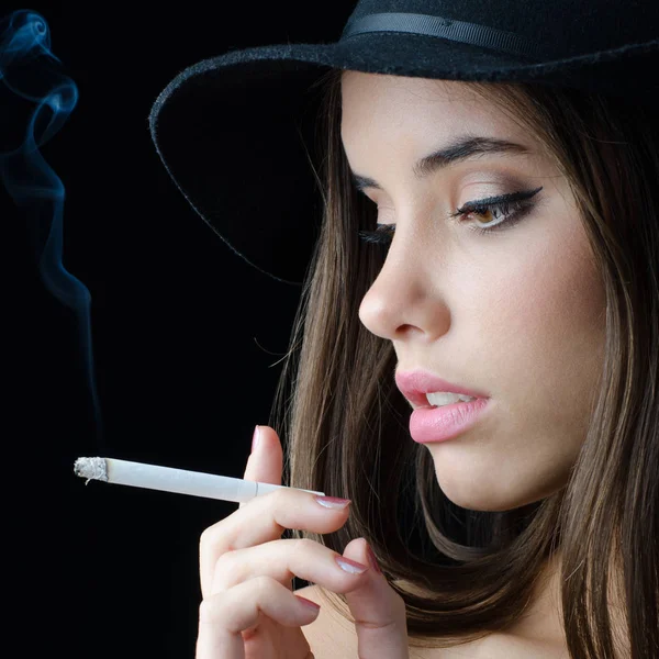 Retrato de la hermosa chica elegante fumar cigarrillo aislado sobre fondo negro Imagen de stock