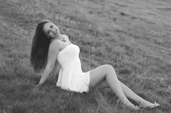 美しい春の日に牧草地に座っている幸せのエレガントな女性 — ストック写真