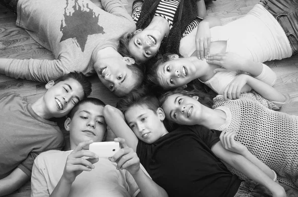 Gli amici adolescenti si divertono sul pavimento — Foto Stock