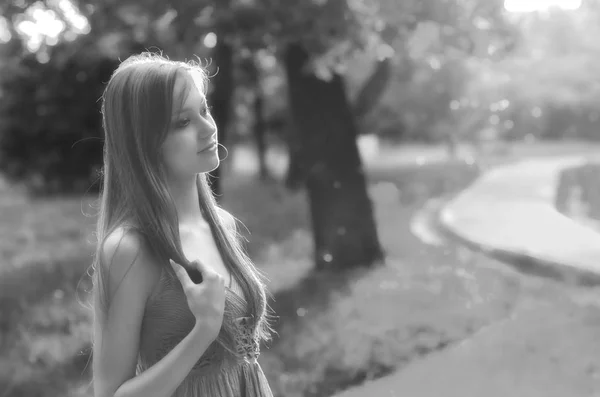 Schöne Mädchen, die an einem sonnigen Sommertag in schwarz-weiß in der Natur spazieren gehen — Stockfoto