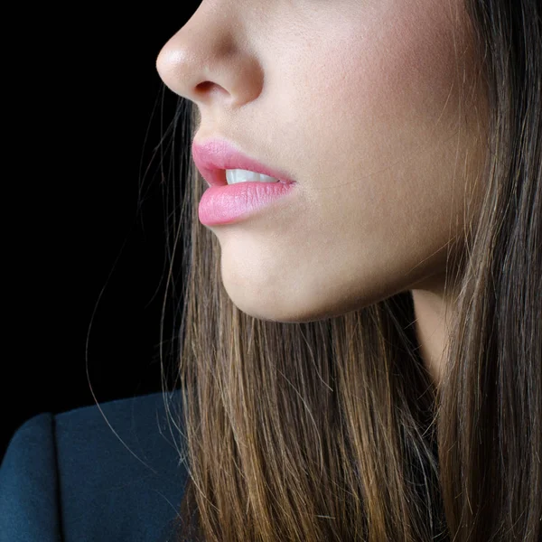 Portrait of the brunette girl in black jacket showing only her nose, mouth and long brown hair — Stock Photo, Image