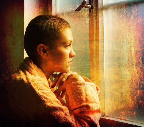Young cancer patient standing in front of hospital window — Stock Photo, Image
