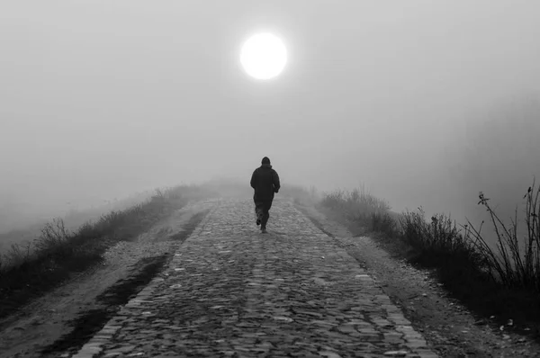 Homem correndo na natureza no dia de outono nebuloso em preto e branco — Fotografia de Stock