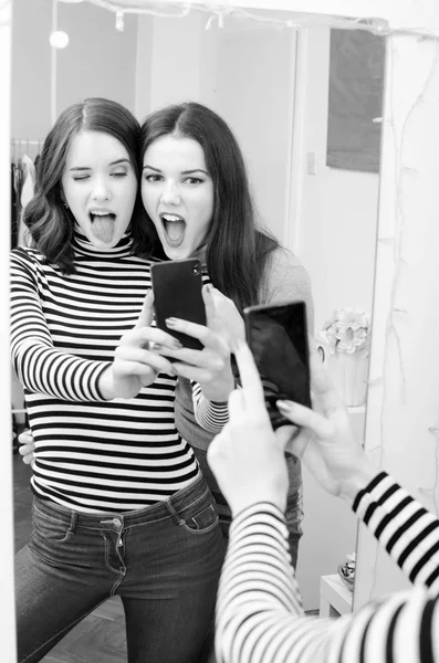 Dos hermosas chicas adolescentes tomando selfies mientras hacen caras en —  Fotos de Stock