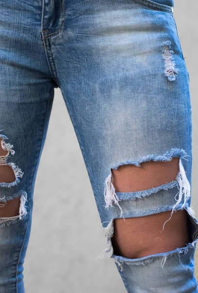 Menina com pernas longas vestindo calças de jeans rasgadas na moda Imagens Royalty-Free