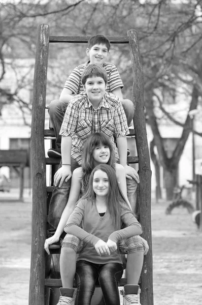 Tonåriga pojkar och flickor att ha kul på den park lekplatsen i svart och vitt — Stockfoto