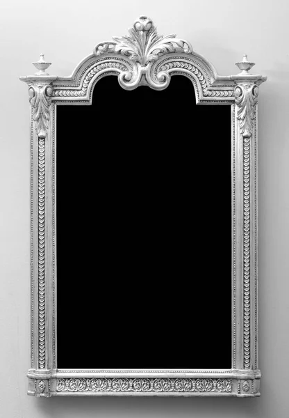Beautiful antique wooden mirror frame mounted on the wall