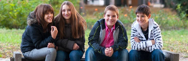 Fyra tonåriga vänner har kul i parken — Stockfoto