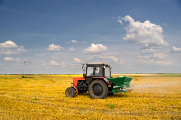 Traktor szóró műtrágya a mezőgazdasági területen a betakarítás után Jogdíjmentes Stock Fotók