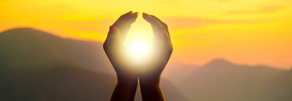 Руки женщины держат солнце — стоковое фото