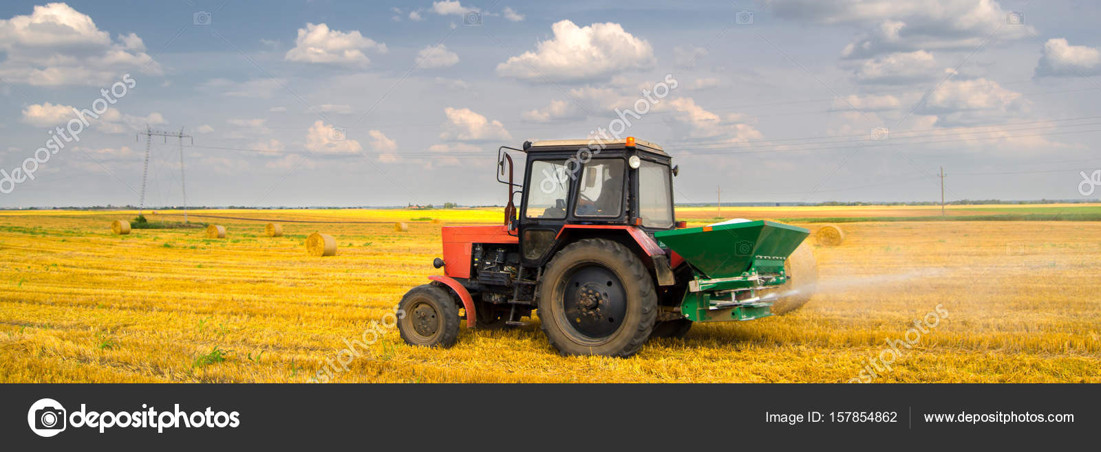 Tractor spraying fertilizer on the agricultural field after harvest