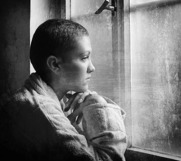 Paciente joven con cáncer mirando por la ventana del hospital en blanco y negro — Foto de Stock