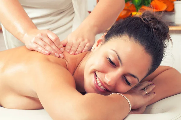 Mujer feliz disfrutando de masaje de espalda profesional en el salón de belleza moderno —  Fotos de Stock