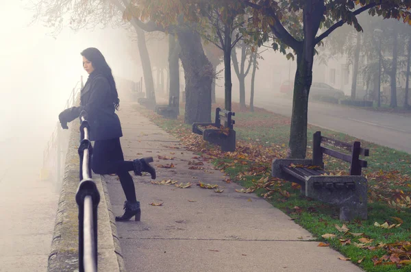 Young woman on the street on foggy autumn day — Stock Photo, Image