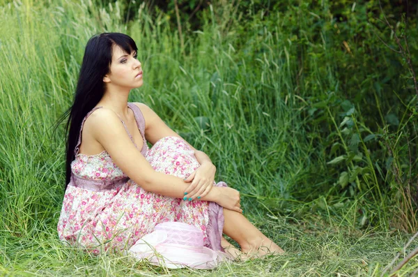 Mulher sentada no prado de verão — Fotografia de Stock