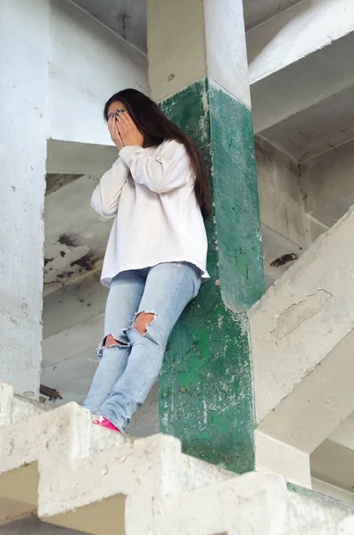 Femme déprimée pleurant dans un bâtiment abandonné — Photo