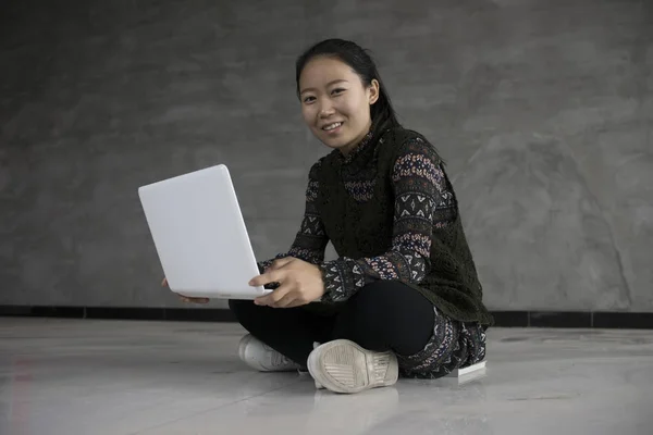 亚洲女孩坐在地板上使用笔记本电脑 — 图库照片