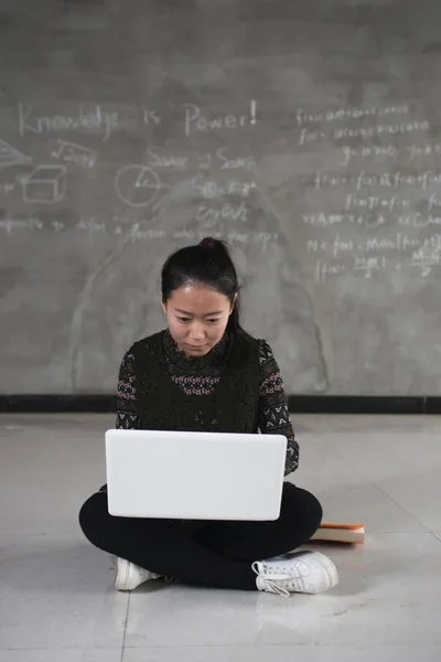 Kız öğrenci dizüstü bilgisayar kullanmak yerde çalışma — Stok fotoğraf