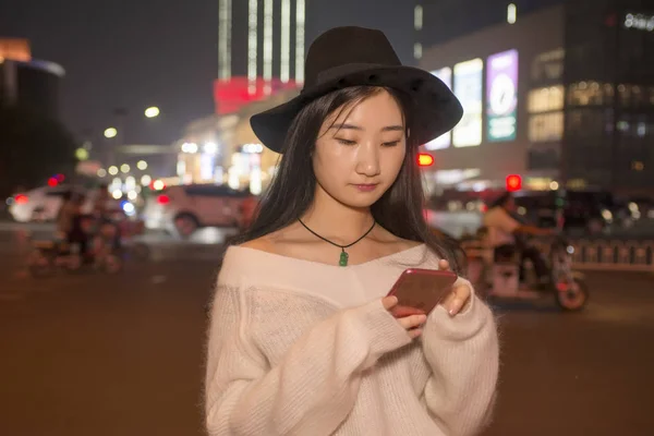 Piękna dziewczyna korzystanie z telefonu komórkowego na ulicach w nocy — Zdjęcie stockowe
