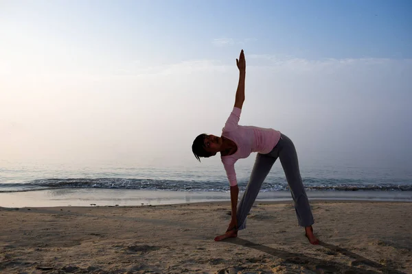 Девушка с йоги на пляже — стоковое фото