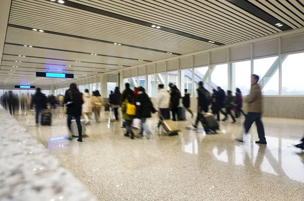 People were in a hurry to catch the train.It\'s on the long corridor of the station.