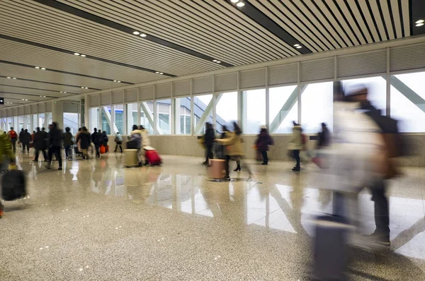 People were in a hurry to catch the train.It\'s on the long corridor of the station.