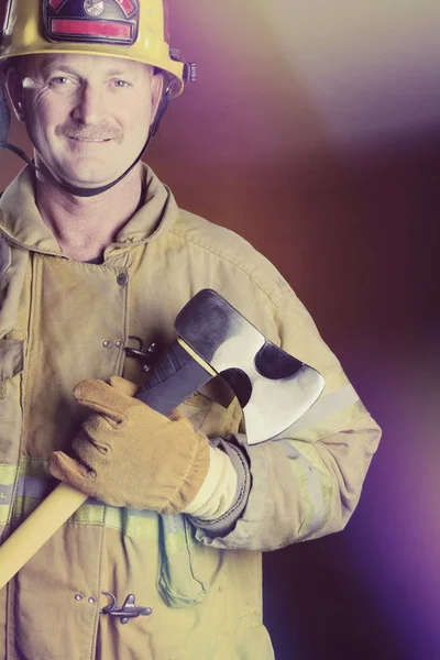 Lachende brandweerman houdt bijl — Stockfoto