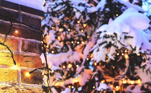 Brick wall Christmas background with lights glowing and snow — Stock Photo, Image
