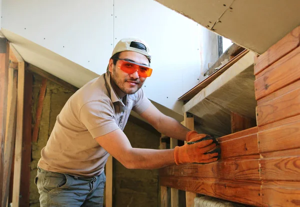 Homem que mede trilho em casa durante a construção — Fotografia de Stock