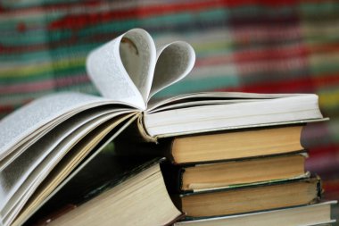 Kitap sayfaları renkli arka plan üzerinde şeklinde kalp ile açıldı