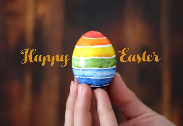 Happy Easter egg w ręku na podłoże drewniane, karty z pozdrowieniami — Zdjęcie stockowe