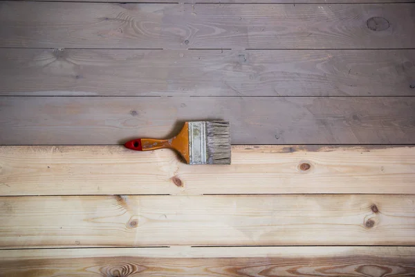 Suelo de madera pintado con color gris y un pincel en el suelo . — Foto de Stock